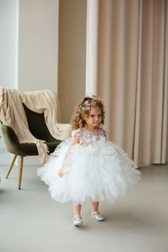 Looking for the perfect dress for your little one's special occasion? Look no further than this beautiful white flower girl dress! Crafted with exquisite attention to detail, this dress is sure to make your little girl feel like a princess on her big day. The delicate tulle tutu and intricate floral detailing are perfect for a first birthday, baptism, first communion, or pageant event. The dress is made from high-quality materials that are gentle on your baby's delicate skin. The soft tulle skir White Tulle First Communion Dress With Tulle Skirt, White Princess Baptism Dress With Tulle Skirt, White Tulle First Communion Dress With Ruffles, White Tulle Baptism Dress For Pageant, White Baptism Dress With Tulle Skirt For Pageant, White Tulle Princess Dress For First Communion, White Ruffled Pageant Dress For First Communion, White Tulle Pageant Dress For First Communion, Elegant First Birthday Tulle Tutu Dress