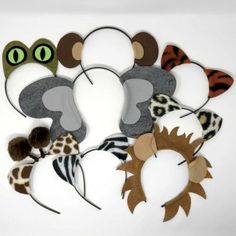 several different animal headbands are arranged on a white surface with green eyes and brown ears