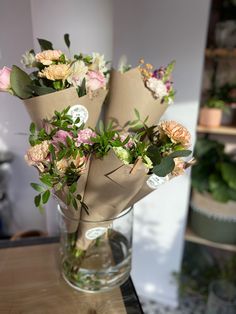 some flowers are sitting in a vase on a counter top with paper wrapped around them