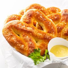 a basket filled with pretzels next to dipping sauce