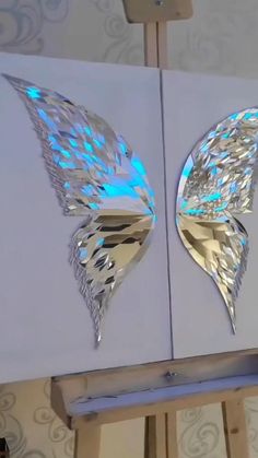 two mirrors with wings on them in front of a wall