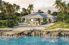 the house is surrounded by palm trees and water