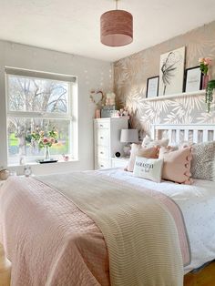 a bedroom with pink and white decor on the walls