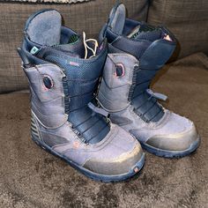 a pair of blue snow boots sitting on top of a couch