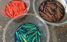 three bowls filled with different colored glass beads