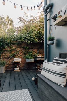 an outdoor patio with potted plants and string lights