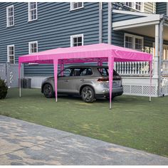 a car parked in front of a house with a pink cover on it's roof