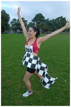 a woman running in a race with her arms up