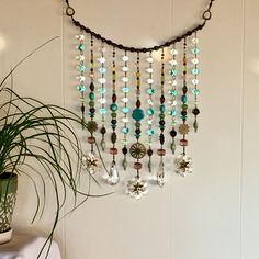 a potted plant sitting next to a wall with beads hanging from it's side