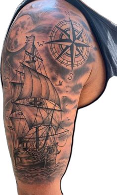 a man's back with a ship and compass tattoo on it