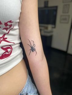 a woman's arm with a spider tattoo on the left side of her body