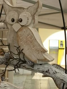 an owl statue sitting on top of a tree branch