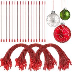 red and green ornaments are hanging from strings