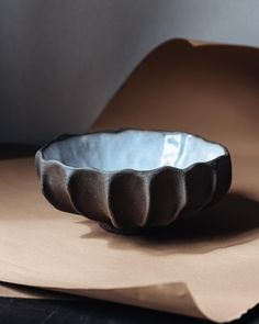 a bowl sitting on top of a piece of brown paper