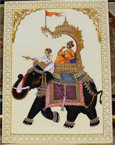 an elephant with two people riding on it's back in front of a wall