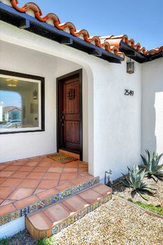 the front entrance to a home with red tile