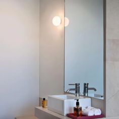 a bathroom with a sink, mirror and soap dispenser on the counter