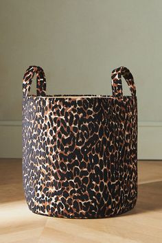 a leopard print basket sitting on top of a wooden floor