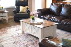 a living room with two leather chairs and a coffee table in the middle of it