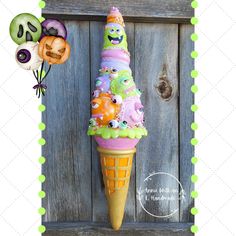 an ice cream cone with monsters on it and balloons attached to the top is in front of a wooden door