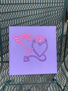 a purple sign with two hearts on it sitting on a metal chair next to a wire fence