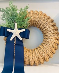 a rope wreath with a starfish on top and a blue ribbon tied around it