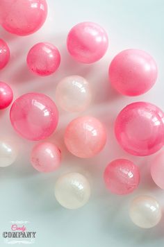 some pink and white balloons are laying on the table together with one balloon in the middle