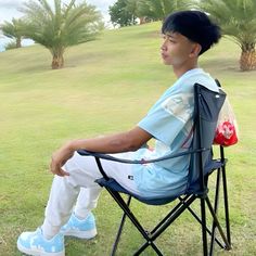 a man sitting in a chair on top of a lush green field