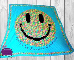 a blue blanket with sprinkles on it and a smiley face in the middle