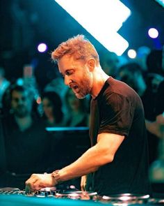 a man that is standing in front of a dj's turntable at a party