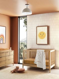 a baby's room with a crib, dresser and large window looking out onto the outdoors