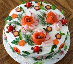 a white cake decorated with orange flowers and green leaves on a wooden table top, ready to be eaten