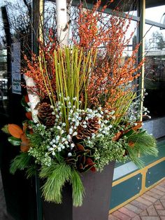 a planter filled with lots of different types of flowers and greenery on the side of a building