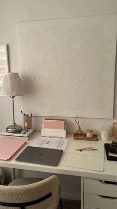 a white desk topped with a laptop computer next to a lamp