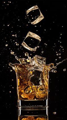 an ice cube falling into the water on a black background with some bubbles around it