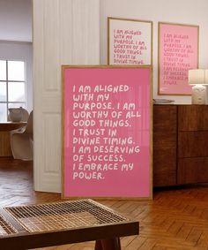 a pink poster on the wall in a room with wooden flooring and white walls