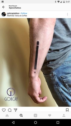 a person with a black ink pen tattoo on their arm