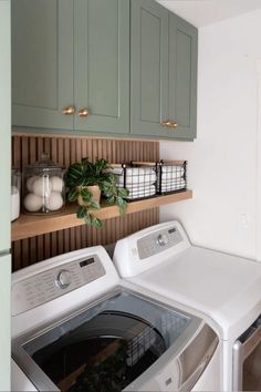 a washer and dryer in a room with green cupboards on the wall