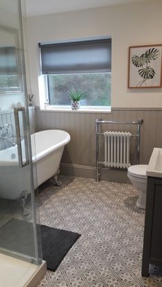 a bathroom with a bathtub, toilet and sink next to a window in it