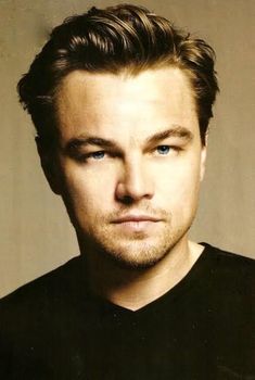 a close up of a person wearing a black shirt and looking at the camera with a serious look on his face