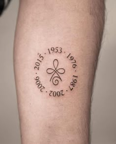 a man with a tattoo on his leg that reads, date 2011 - 2013 and has a cross in the middle