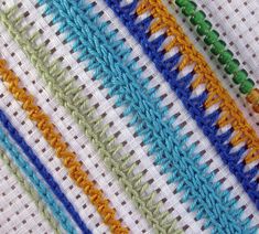 several crochet stitches are laid out on a tablecloth with different colors and sizes