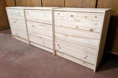 two wooden drawers sitting next to each other in a room with wood paneling on the walls