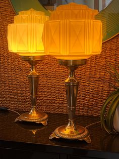 two lamps sitting on top of a table next to a mirror