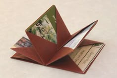 an origami card holder made out of folded paper with pictures on the front