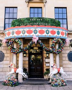 the front entrance to an ornate building decorated for christmas with wreaths and decorations on it