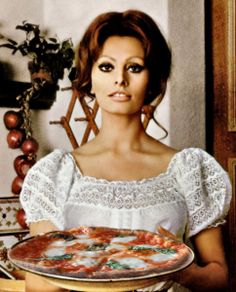 a woman holding a plate with food on it