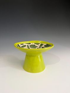 a small green bowl sitting on top of a white table