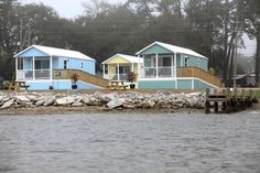 two houses on stilts next to the water