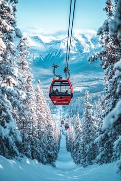 a ski lift with people on it in the middle of snow covered trees and mountains